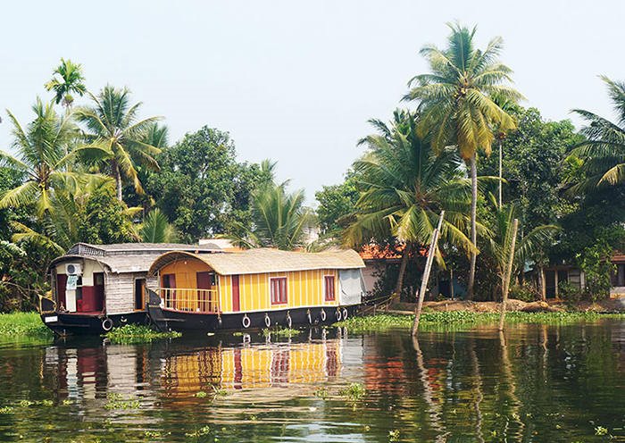 Casa flotante: una de las actividades más tranquilas y relajantes que puede hacer en Kerala es hacer un viaje en una casa flotante a lo largo de los canales de Kerala bordeados de palmeras.